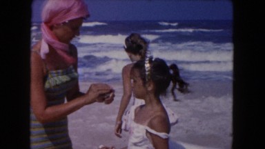 1960: cool gypsy mother putting sunscreen on daughters FLORIDA