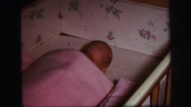 1972: newborn baby girl moving and trying to sleep on her cradle LYNBROOK