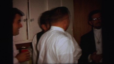 1972: well dressed people gathered in the kitchen at party LYNBROOK, NEW YORK