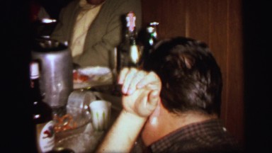 1972: people gathered around table preparing to eat birthday cake LYNBROOK