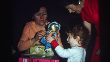 1974: christmas tree is seen with child opening presents LYNBROOK, NEW YORK