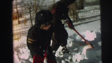 1974: two boys are clearing the ice from the ground with shovels LYNBROOK