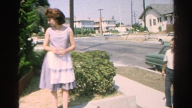 1966: Two Men and Woman Trying to Catch Cat Climbing Brick Wall California