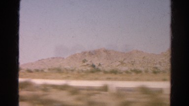 1966: Rugged Dirt Road Cutting Through Mountains Seen From Moving Vehicle