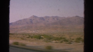 1966: view from moving car during road trip mountains west desert horizon
