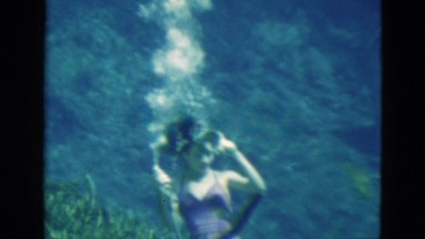 1952: woman demonstrates that she can drink from a bottle while under water