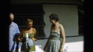 1952: group of women and men standing by a house with coke bottles CAMDEN
