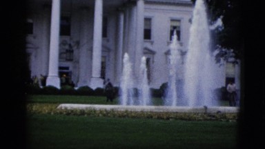 1952: view of the white house with maintenance staff working in the front yard