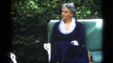 1952: a woman and a man, both in very formal suits, talking in a garden area