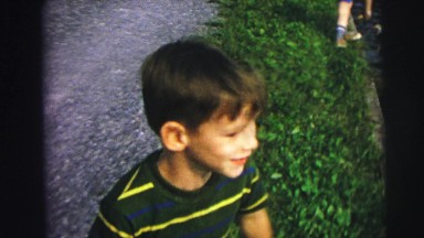 1974: two happy children gather at a pond to feed the ducks at the local park