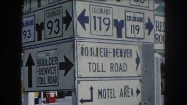 1962: a large sign featuring various route markers and highway signs in colorado