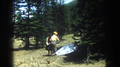 1962: two women outdoors, throwing something at the camera and then pulling pine