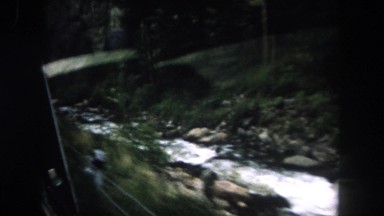1962: a stream running beside the road observed from a moving vehicle