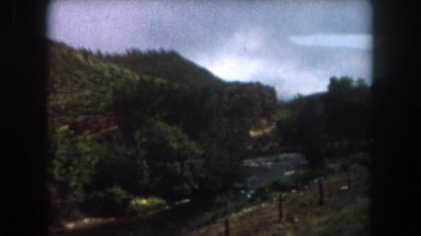 1962: view from a moving train of a winding valley and river