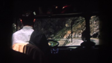 1962: a vehicle going through a somewhat narrow road in a mountainous area