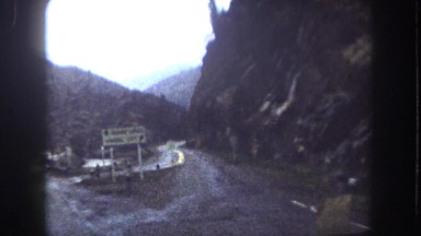 1962: a road cutting through a mountain as seen from a moving vehicle MINNESOTA