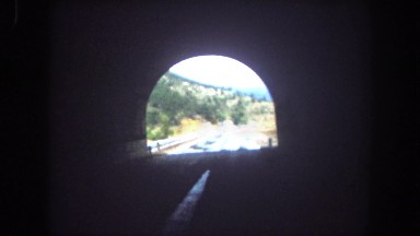 1962: view from car driving inside and outdoor tunnel near mountains on road