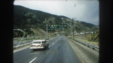 1962: an early 1960's station wagon passes a vehicle on i-70 near idaho springs