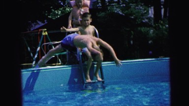 1964: a boy diving into a swimming pool and swimming underwater CAMDEN