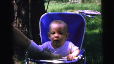 1964: person is bouncing an infant's chair with their foot entertaining the baby