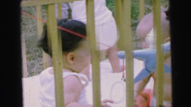 1964: several babies playing together with a toy in a crib CAMDEN, NEW JERSEY