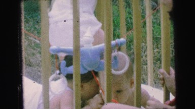 1964: toddler crawling newborn cute lying down resting caged net area CAMDEN