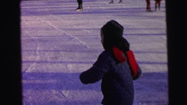 1964: a child with a red scarf ice-skating and then falling down on the ice