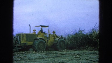 1965: a man on a tractor with a backhoe lifts and carries debris away MEXICO