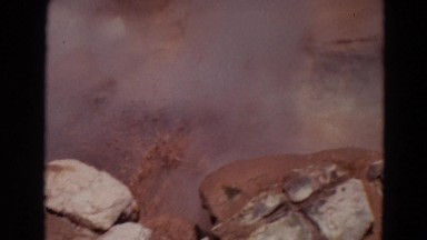 1967: molten lava spilling out violently on to rocks with steam rising up