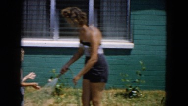 1961: people playing outdoor in the water from the garden hose MICHIGAN