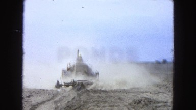 1965: Man Operating Large Machine Plowing Cornfield in Mexico