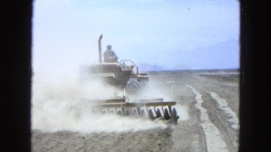 1965: farmer plowing flat dusty field on farm vehicle MEXICO
