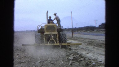 1965: two men ploughing the land with a tractor near to highway MEXICO
