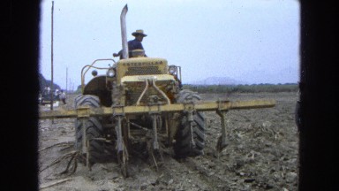 1965: man climbing a moving tractor during a working day MEXICO