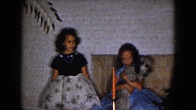 1961: two young girls pass a reluctant dog from one to the other/ MICHIGAN