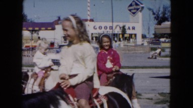 1961: several children riding ponies in a circle at a town carnival MICHIGAN