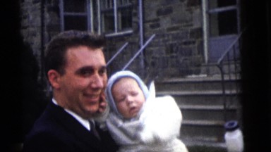 1964: proud father and mother show off baby who is dressed in white