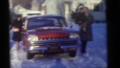 1964: a family walks around their car in the snow. CAMDEN, NEW JERSEY