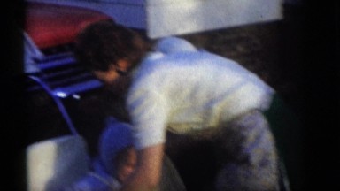 1964: mother bundling up baby boy in stroller for neighborhood walk CAMDEN