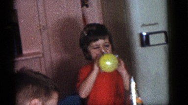 1964: girl is bubbling the balloon in a party friends seeing it CAMDEN