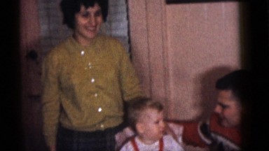 1964: toddler seated in front of a birthday cake and presented with a toy