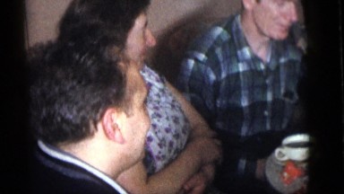 1964: people gathered around a table drinking and laughing CAMDEN, NEW JERSEY