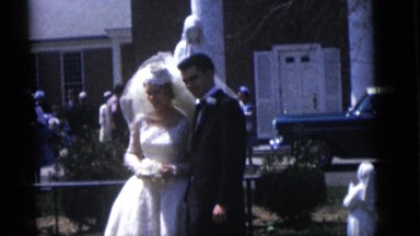 1964: bride and groom posing for pictures outdoor of a church on their wedding