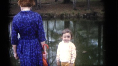 1964: an old family playing with the kids, having fun near the lake