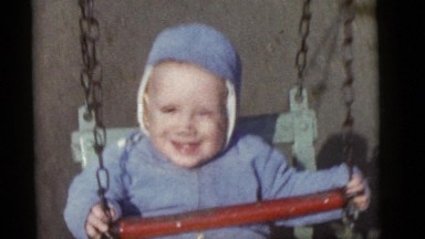 1964: a baby boy riding a swing. CAMDEN, NEW JERSEY