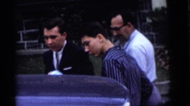 1964: a family loads a newborn baby into the car while the proud grandfather