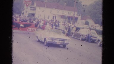 1963: a car is leading a parade with a lady sitting high in the back