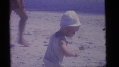 1964: toddler carrying a shovel with sand at the beach CAMDEN, NEW JERSEY