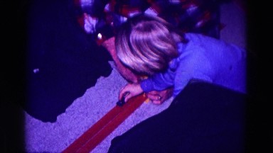 1968: boy in blue shirt racing toy cars on tracks with older man helping set up