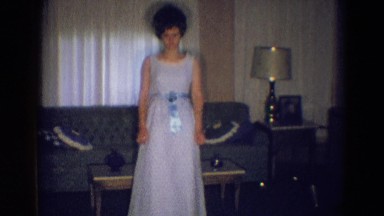 1969: a white woman in an elegant suit and a hair styling walking through a room